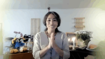 Dohee Lee, Tamalpa faculty, Korean woman with long curly gray and black hair leaning forward smiling